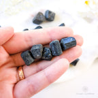 Black stones held in a hand, with a white backround and some more black stones. Available online at Inner Nurture, an Australian crystal store. 