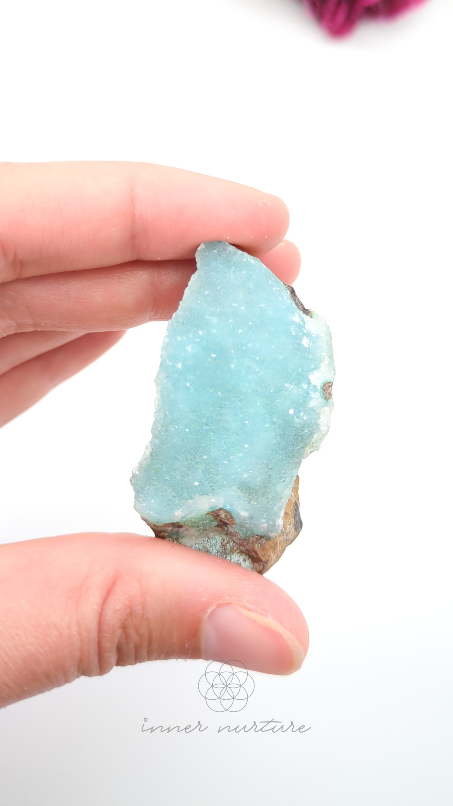Hand holding a light blue crystal with a white background. Malacolla Specimen, Drusy Coated On Dolomite - #12 at Crystal Shop Online Australia called Inner Nurture