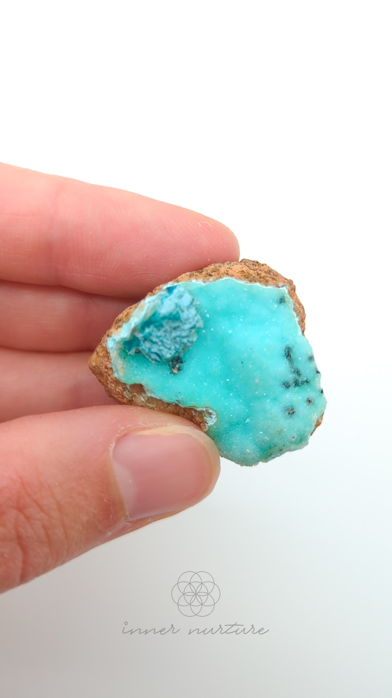 Turquoise crystal rock held in a hand against a white background. Malacolla Specimen, Drusy Coated On Dolomite - #20 at Crystal Shop Online Australia called Inner Nurture