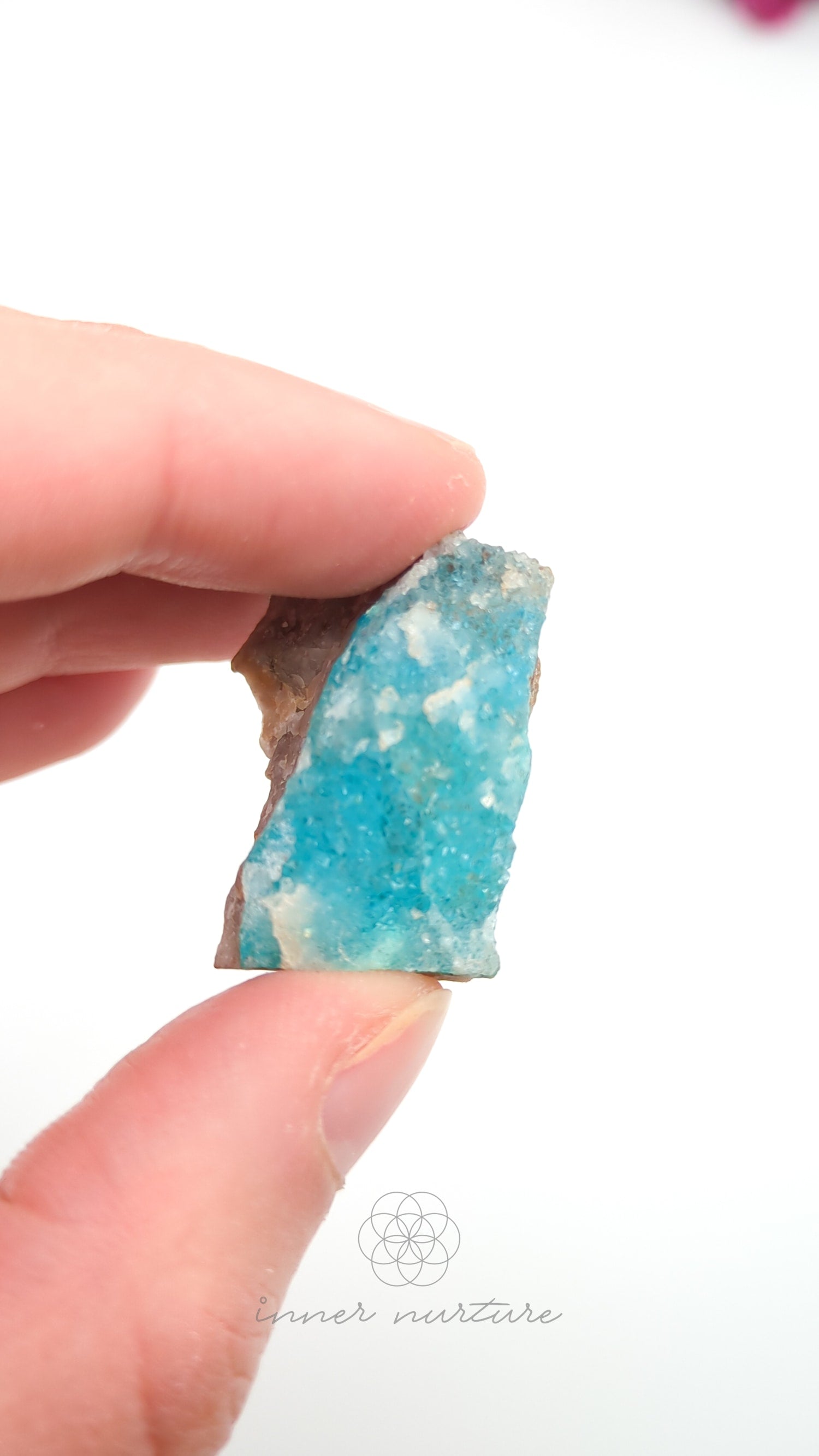 Hand holding a blue crystal against a white background. Malacolla Specimen, Drusy Coated On Dolomite - #21 at Crystal Shop Online Australia called Inner Nurture