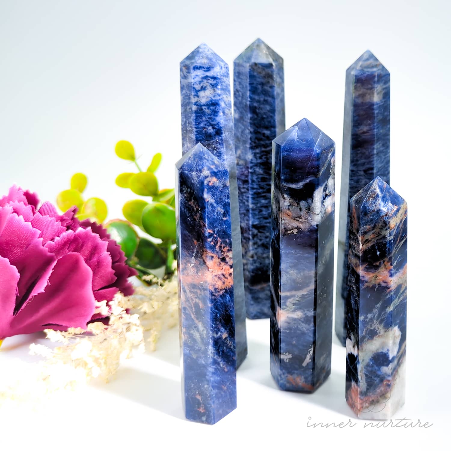 Set of crystal towers with floral and greenery on a white background. Sodalite Generator Tower available to Buy from Inner Nurture - an online Crystals shop in Australia