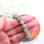 Beaded bracelet on a wooden coaster. Labradorite bead bracelet sold by Inner Nurture, an online australian crystal shop. 