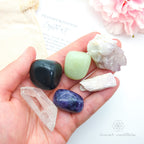 Hand holding various crystals with a soft background and 'inner nurture' branding. Transformation Crystal Kit, available on line in Australia at Inner Nurture