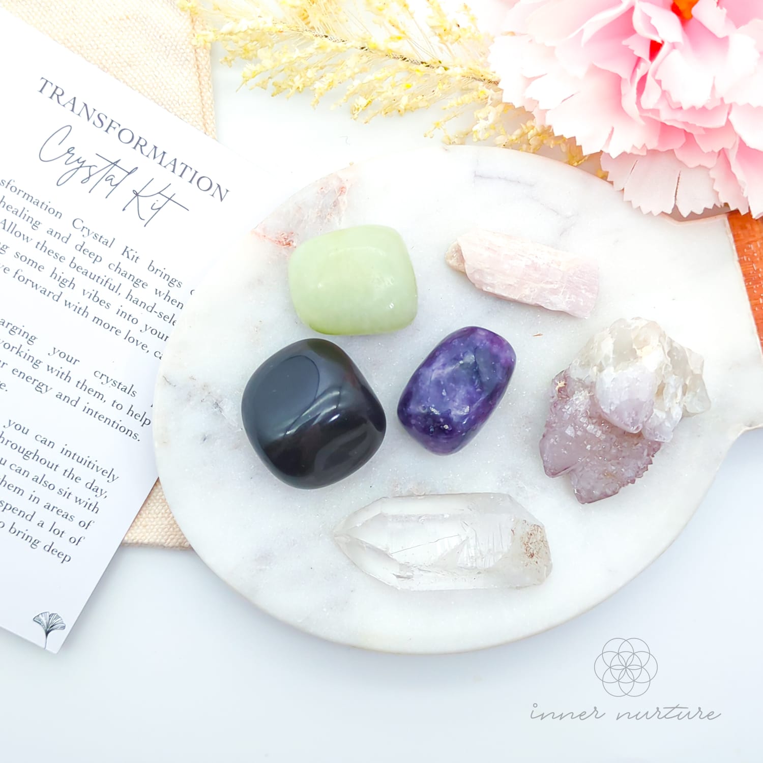 Crystal kit with stones on a marble surface, including a leaf and flowers. Transformation Crystal Kit, available on line in Australia at Inner Nurture