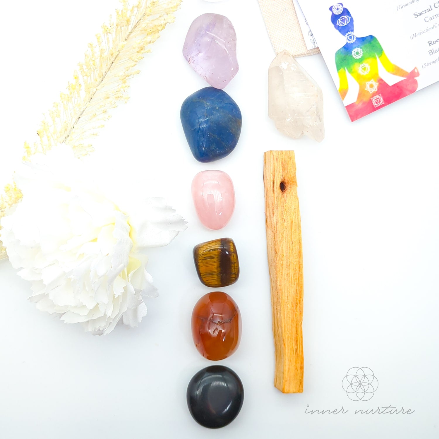 Collection of crystals and a wooden tool on a white background with 'inner nurture' branding. Chakra Balancing Crystal Kit, available on line in Australia at Inner Nurture