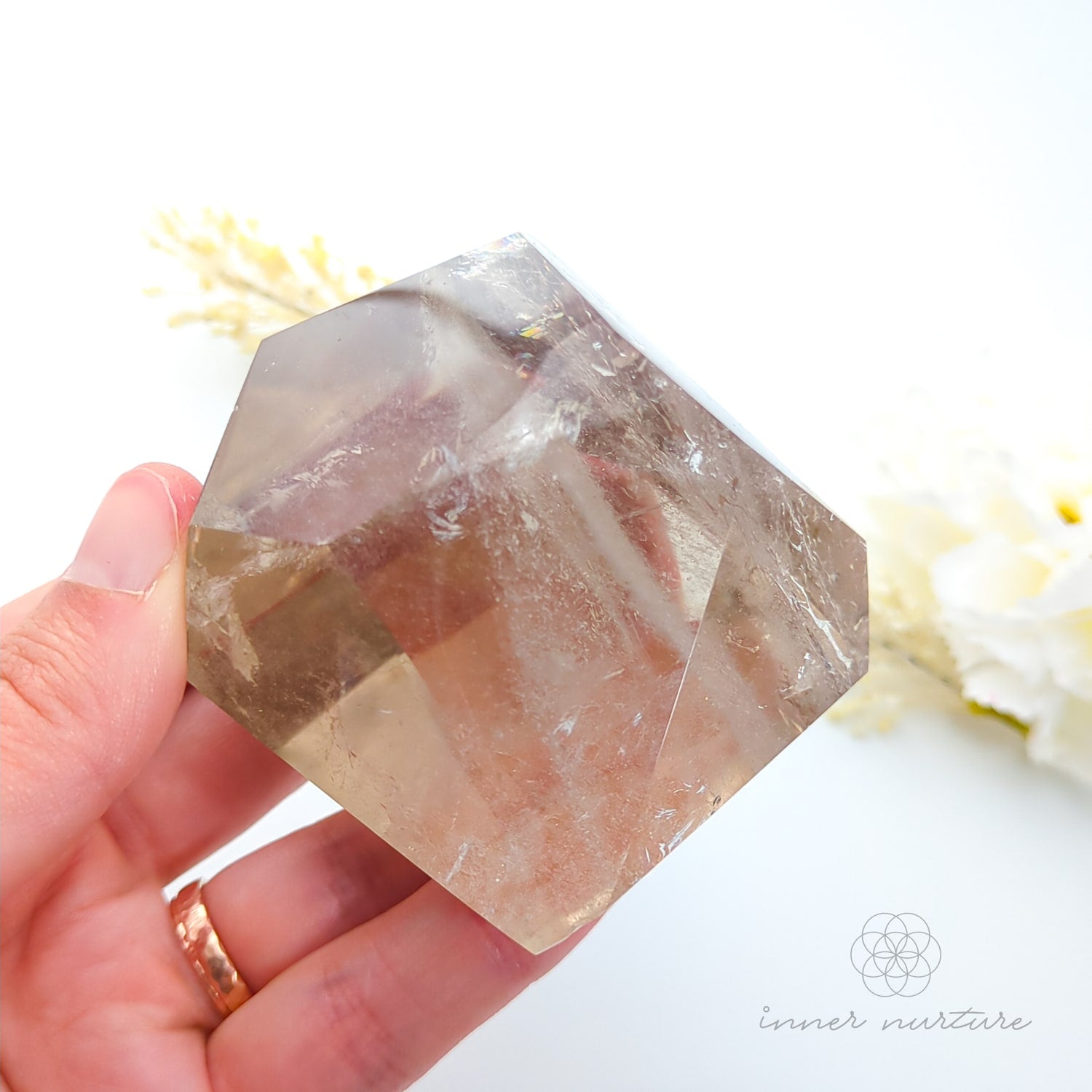 Hand holding a citrine quartz crystal with a blurred natural background. Citrine (Natural) Free Form #1 for Abundance & Manifestation | Crystals Australia Inner Nurture