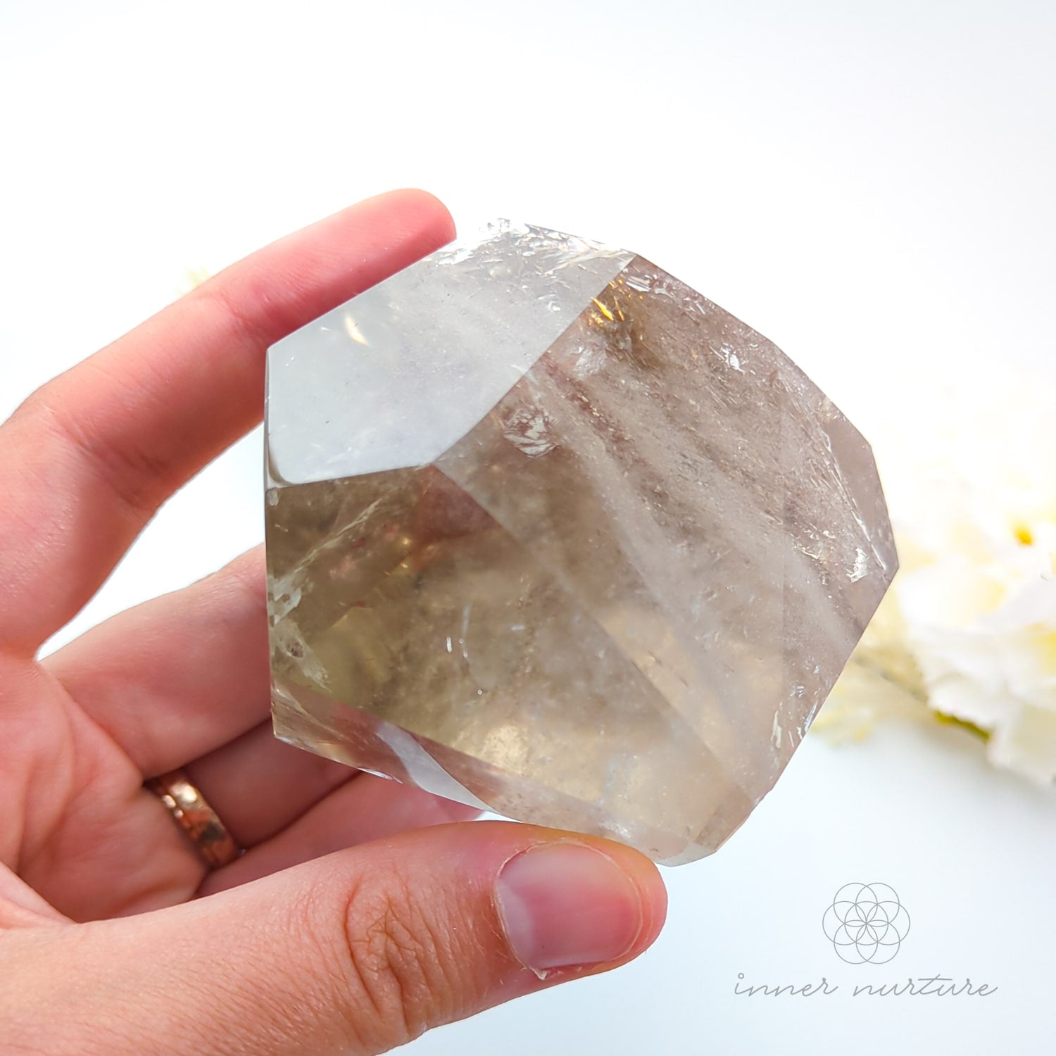Hand holding a citrine crystal with a blurred natural background. Citrine (Natural) Free Form #1 for Abundance & Manifestation | Crystals Australia Inner Nurture