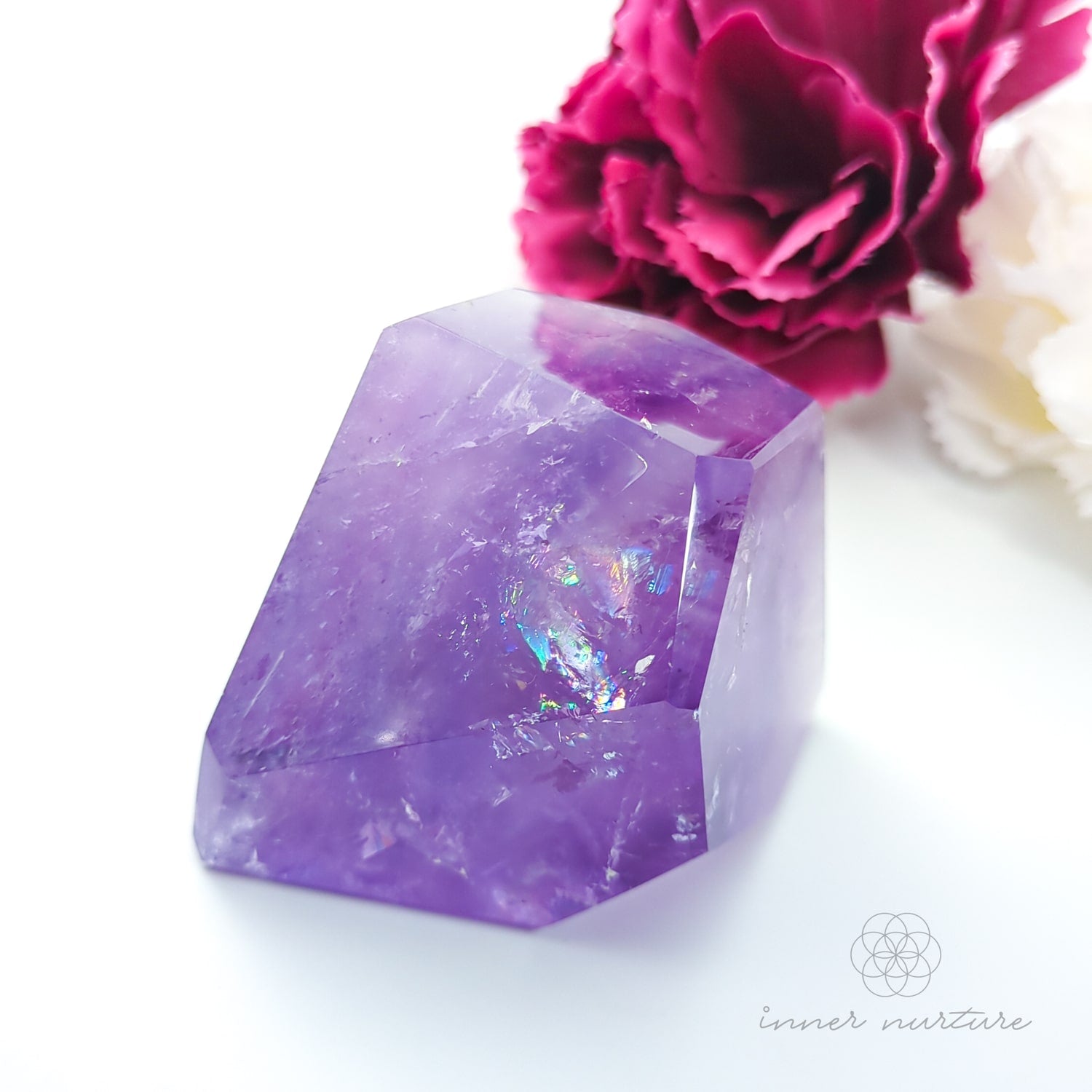 Purple crystal with a pink rose on a white background. Amethyst Free Form #1 for Calm & Clarity | Crystals Australia