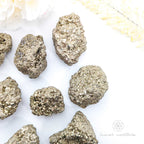 Pyrite crystals on a white background with 'inner nurture' branding. Pyrite crystal cluster available online at Inner Nurture Crystals Australia
