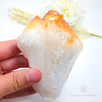 Crystal rock held by a hand with a blurred natural background. Citrine crystal available online at Inner Nurture Crystals Australia